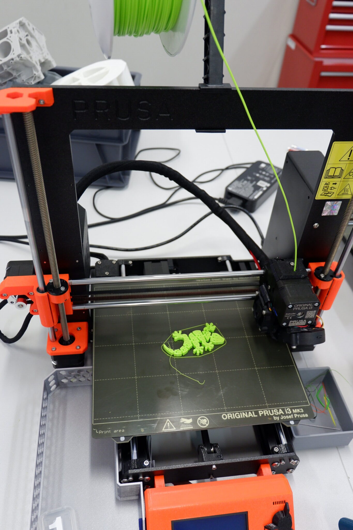 Na zdjęciu drukarka 3D z wydrukowaną jaszczurką.
